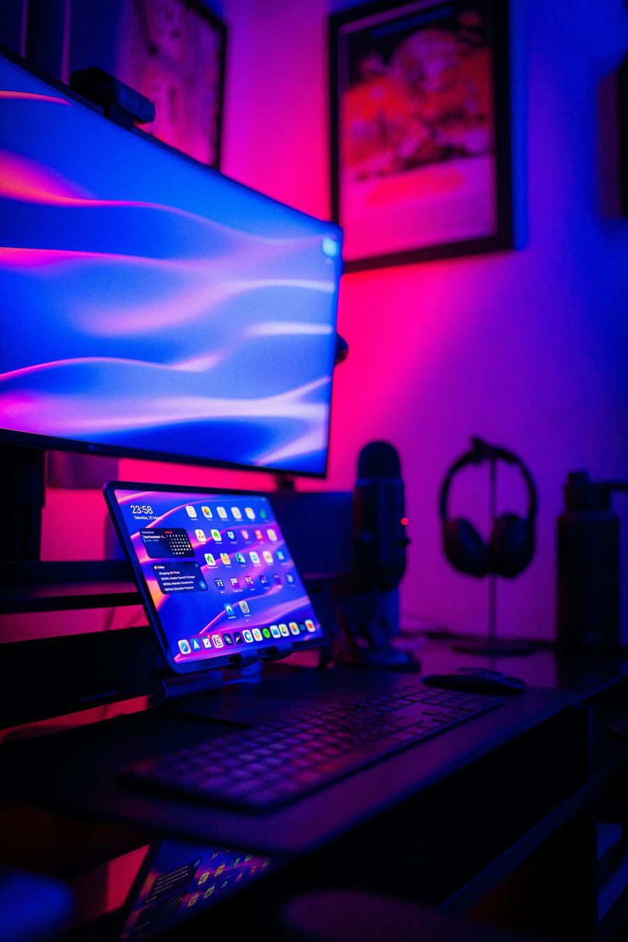 Home office with ambient color lighting behind monitors
